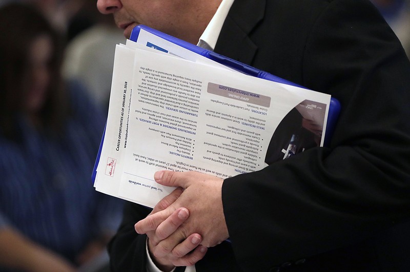 FILE - In this Jan. 30, 2018 file photo, a job applicant talks with company representatives at a JobNewsUSA job fair in Miami Lakes, Fla.  Jobs report on Friday, Dec. 7, for November is expected to point to a solid economy for most Americans, with steady hiring, a low unemployment rate and faster wage gains. If so, it would provide a dose of welcome news after this week’s frantic financial market gyrations, which have been driven by concerns that the U.S.-China trade war could escalate and weaken a U.S. economy already facing higher interest rates and slowing global growth.   (AP Photo/Lynne Sladky, File)