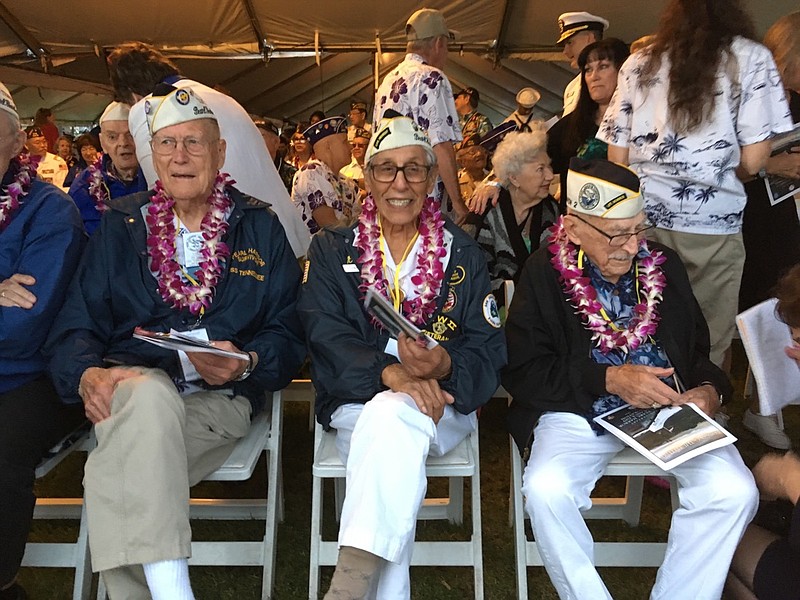 Tom Berg, left, of Port Townsend, Wash., Robert Fernandez, center, of Stockton, Calif., and George Keene of Newhall, Calif., all survivors of the 1941 Japanese attack on Pearl Harbor, take part in the 77th anniversary ceremony Friday, Dec. 7, 2018, at Pearl Harbor, Hawaii. The Navy and National Park Service jointly hosted the remembrance ceremony at a grassy site overlooking the water and the USS Arizona Memorial. (AP Photo/Audrey McAvoy)