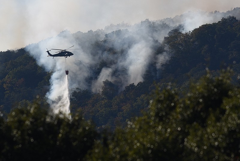 A Tennessee National Guard helicopter dumps water, Oct. 11, 2016, on the fire that has burned on Walden's Ridge since Saturday near Soddy-Daisy.