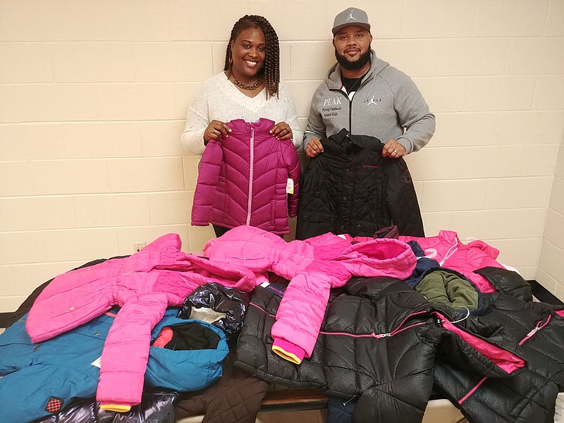 Thanks to financial donations from the community, LaDarius Price, right, donates 20 coats to Orchard Knob Elementary School family partner specialist E'tienne Easley for distribution to select students. "For some of them, they may never have had a new coat," Price said, adding, "I always buy them what I would buy my own kids."