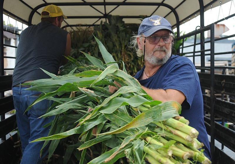 In this 2009 staff file photo, John Corley, right, unloads corn stalks from a truck at Linda's Produce with Jonathan Hair, left. Mr. Hair brought the corn stalks from his Polk County farm, and they will be sold for fall decorations.
