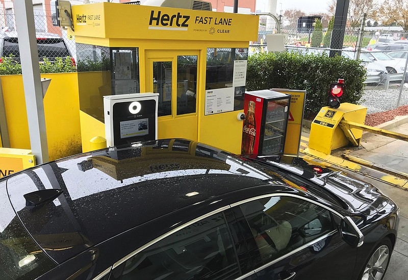 In this Friday, Dec. 7, 2018, photo, a rental car approaches a biometric scanning machine at the exit of the Hertz facility at Hartsfield-Jackson Atlanta International Airport, in Atlanta. In a first for the rental car industry, Hertz is teaming up with Clear, the maker of biometric screening kiosks found at many airports and stadiums. Hertz says the partnership will slash the time it takes to pick up a rental car. (AP Photo/Jeff Martin)
