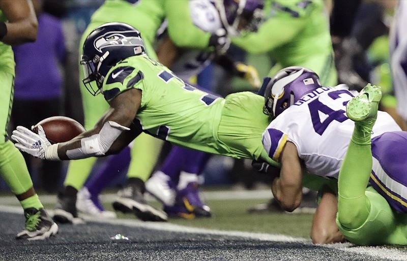 Seattle Seahawks' Chris Carson, left, dives into the end zone for a touchdown against the Minnesota Vikings in the second half of an NFL football game, Monday, Dec. 10, 2018, in Seattle. (AP Photo/Ted S. Warren)