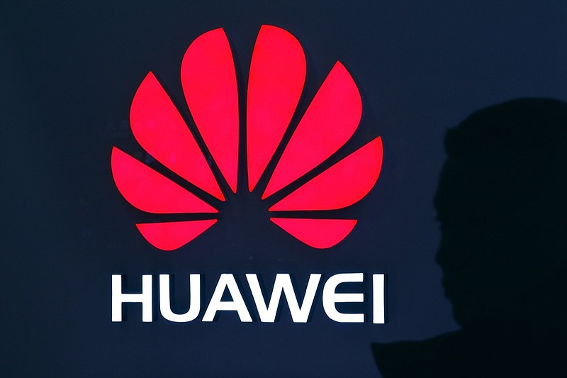 A man is silhouetted as he walks by a Huawei retail store at a shopping mall in Beijing, Tuesday, Dec. 11, 2018. China's foreign minister vowed Tuesday to protect its citizens abroad as a Canadian court decided whether to release a technology executive on bail in a case that has riled U.S.-Chinese relations. (AP Photo/Andy Wong)