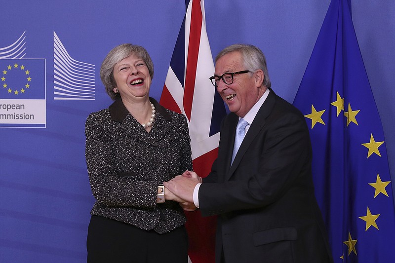 British Prime Minister Theresa May, left, is greeted by European Commission President Jean-Claude Juncker at EU headquarters in Brussels, Tuesday, Dec. 11 2018. Top European Union officials on Tuesday ruled out any renegotiation of the divorce agreement with Britain, as Prime Minister Theresa May fought to save her Brexit deal by lobbying leaders in Europe's capitals. (AP Photo/Francisco Seco)