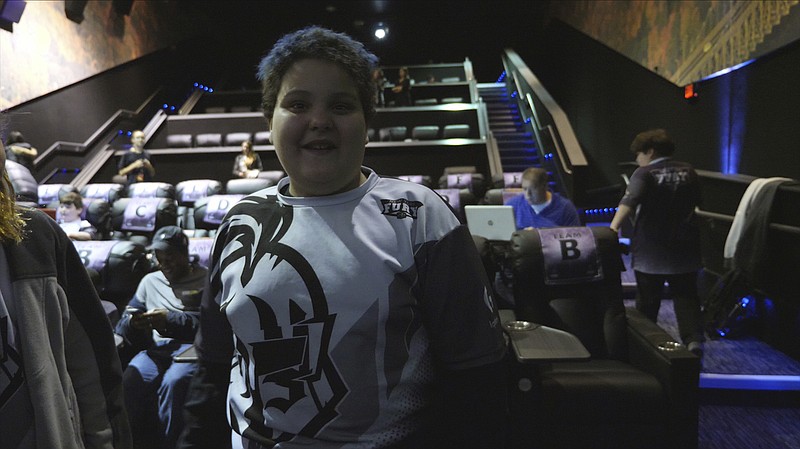 In this Saturday, Nov. 17, 2018, image provided by Super League Gaming, Christian Pineda, 13, poses at a Super League video game competition against a team from Boston at City Center 15 Cinema de Lux in White Plains, N.Y. Pineda claims to be shy at school, but here, he's a vocal leader on a New York team of nearly 20 esports competitors, some as young as 6-years-old. (Maria Gambale/Super League Gaming via AP)