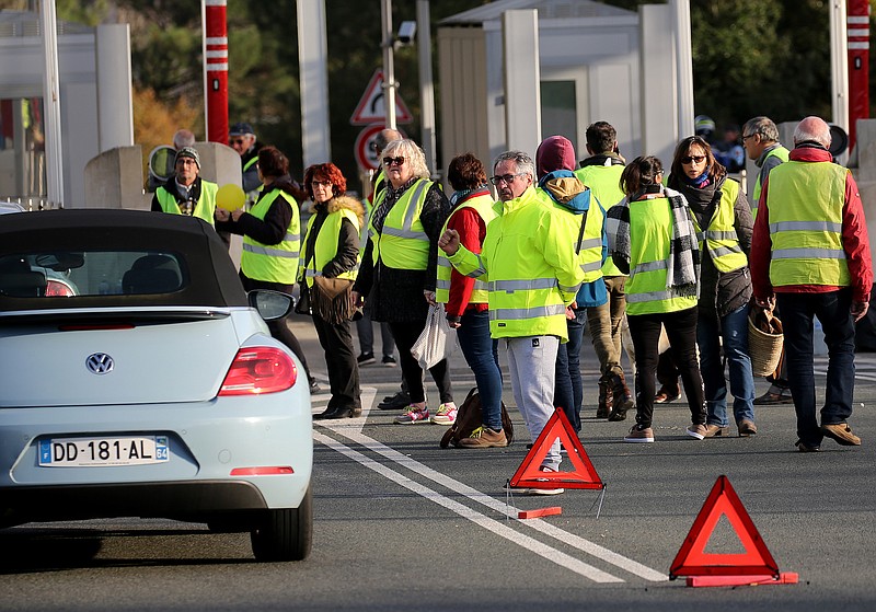 Demonstrators wearing yellow vests protest at the toll gates of a motorway, in Biarritz, southwestern France, on Monday. (AP Photo/Bob Edme)