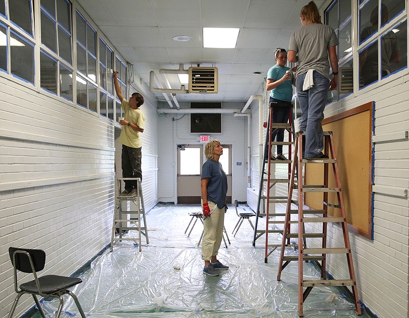 World Changers volunteers help paint windows at Rivermont Elementary School before the school piloted open enrollment during the 2017-18 school year.