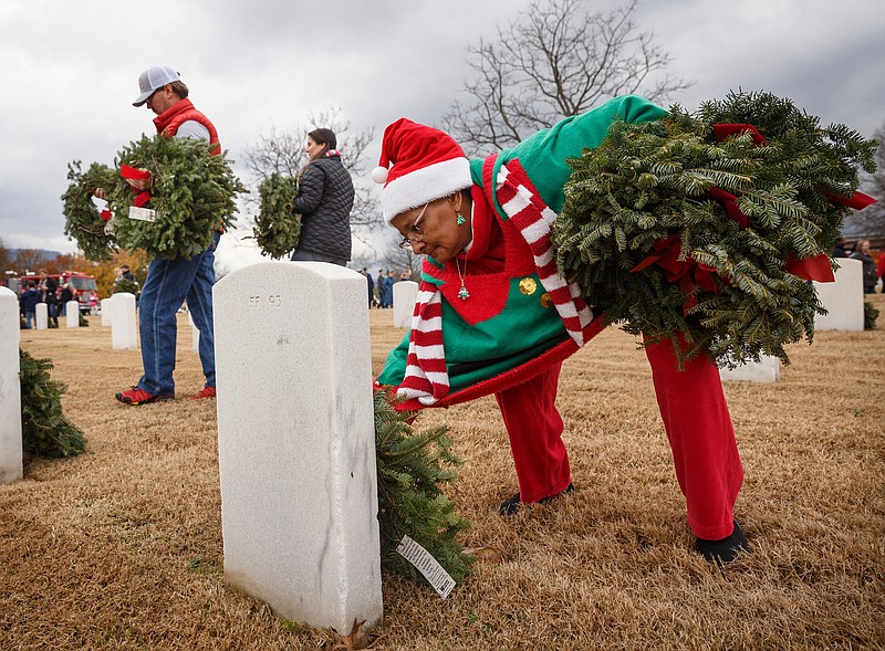 Staff photo by Doug Strickland / Pam Thompson lays a wreath on a grave at the Chattanooga National Cemetery on Saturday, Dec. 15, 2018, in Chattanooga, Tenn. Thousands of volunteers turned out to lay wreaths on graves at the cemetery which were donated by the Worcester Wreath Company through the Wreaths Across America program, which supplies wreaths to national cemeteries across the country.