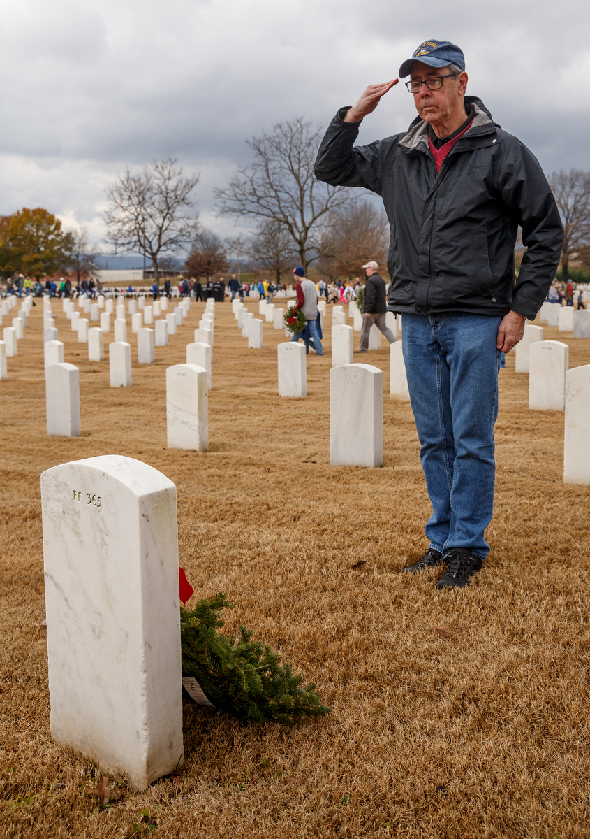 Staff photo by Doug Strickland / Jim Quinn salutes after laying a wreathe on a grave at the Chattanooga National Cemetery on Saturday, Dec. 15, 2018, in Chattanooga, Tenn. Thousands of volunteers turned out to lay wreaths on graves at the cemetery which were donated by the Worcester Wreath Company through the Wreaths Across America program, which supplies wreaths to national cemeteries across the country.