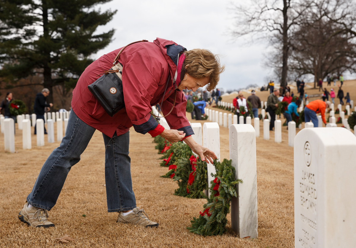 Staff photo by Doug Strickland / Joy Ward lays a wreath on a grave at the Chattanooga National Cemetery on Saturday, Dec. 15, 2018, in Chattanooga, Tenn. Thousands of volunteers turned out to lay wreaths on graves at the cemetery which were donated by the Worcester Wreath Company through the Wreaths Across America program, which supplies wreaths to national cemeteries across the country.