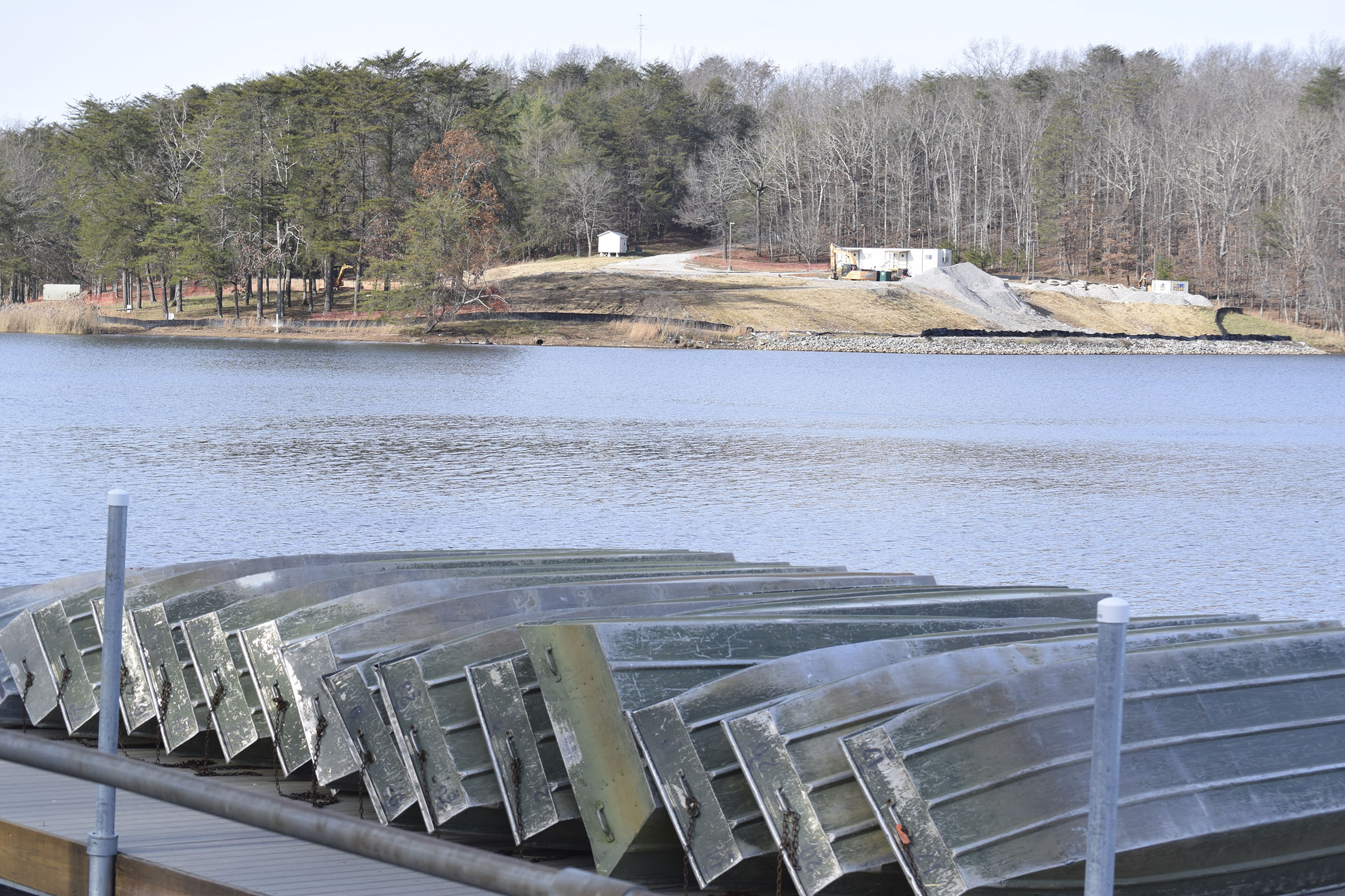 The site of the former Fall Creek Falls State Park Inn is seen across Fall Creek Falls Lake from rental boats stacked on a dock on Dec. 13, 2018.