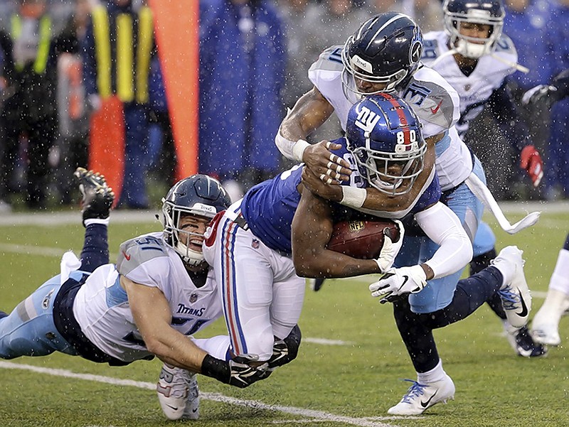 New York Giants wide receiver Jawill Davis, center, is tackled by Tennessee Titans inside linebacker Will Compton, left, and free safety Kevin Byard during the first half of Sunday's game in East Rutherford, N.J. 