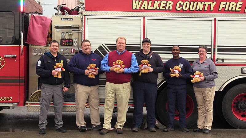 Walker County Fire Chief Blake Hodge, Deputy Chief Nathan Farrow, Mike Herndon, firefighter Ryan Sawyers, firefighter Kolby Mosely and Fire & Life Safety educator Regina Dorsey brandish a few of the teddy bears Herndon donated to Walker County Emergency Services. Herndon also donated 150 sets of coloring books and crayons for WCES' Fire Prevention and Education Department to use in local day cares and schools. (Contributed photo)