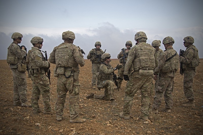 In this Nov. 7, 2018, photo released by the U.S. Army, U.S. soldiers gather for a brief during a combined joint patrol rehearsal in Manbij, Syria. The United States' main ally in Syria on Thursday, Dec. 20, 2018, rejected President Donald Trump's claim that Islamic State militants have been defeated and warned that the withdrawal of American troops would lead to a resurgence of the extremist group. (U.S. Army photo by Spc. Zoe Garbarino via AP)