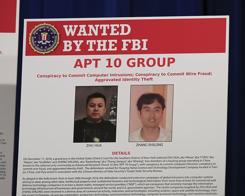 A poster displayed during a news conference at the Department of Justice in Washington, Thursday, Dec. 20, 2018, shows two Chinese citizens suspected to be with the group APT 10 carrying out an extensive hacking campaign to steal data from U.S. companies. The Justice Department is charging two Chinese citizens with carrying out an extensive hacking campaign to steal data from U.S. companies. An indictment was unsealed Thursday against Zhu Hua and Zhang Shillong. Court papers filed in Manhattan federal court allege the hackers were able to breach the computers of more than 45 entities in 12 states. (AP Photo/Manuel Balce Ceneta)

