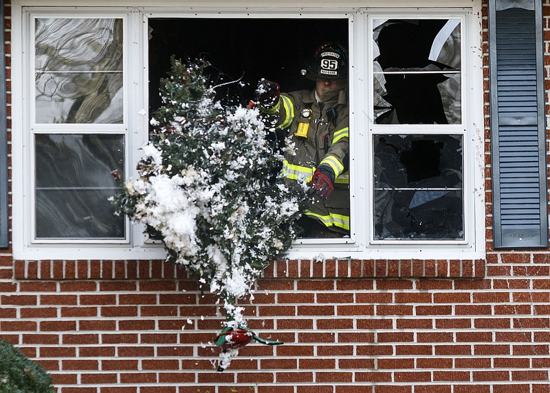 An effort apparently exists, a UCLA professor claims, to keep firefighters, like one here shown tossing a Christmas tree out a window after a 2017 duplex fire in Red Bank, white.