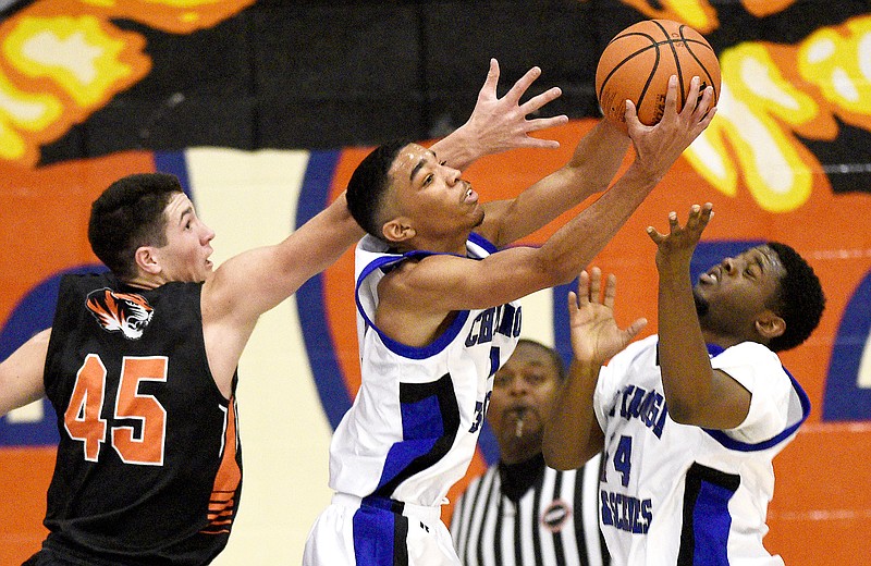 Arts & Sciences' Troy Pride pulls down a rebound against Meigs County's Caleb Newman, left, and beside teammate tony Orr during a game in the Chatt-Town Classic on Friday night at Chattanooga State.