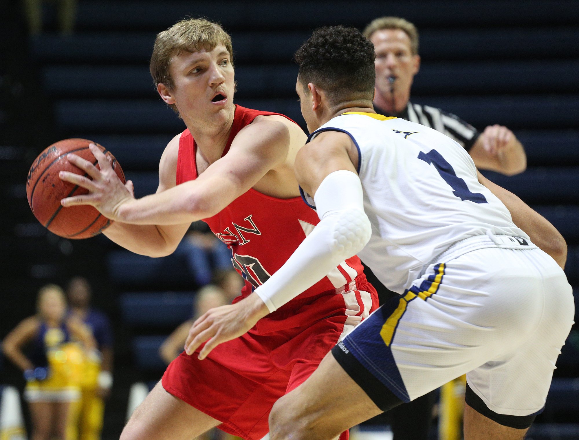 Bryan College's Austin Douglas (10) looks to pass the ball while being guarded by University of Tennessee at Chattanooga's Jonathan Scott (1) during the UTC vs. Bryan College boys basketball game Friday, December 21, 2018 at McKenzie Arena in Chattanooga, Tennessee.