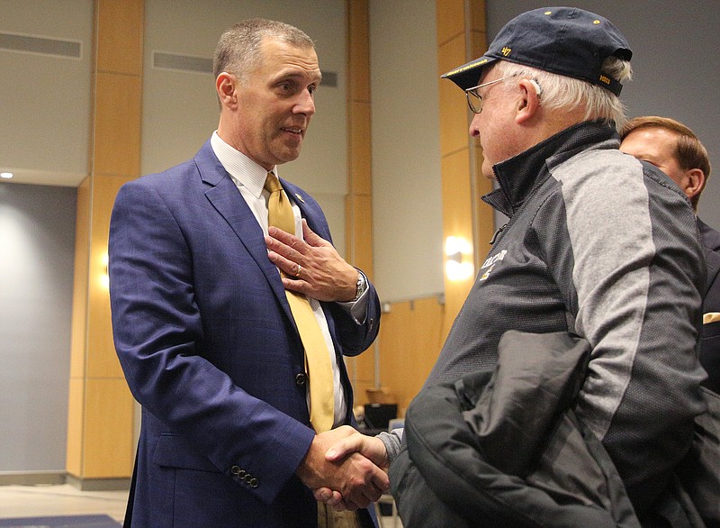 New UTC football coach Rusty Wright, left, speaks with Cecil Hammontree after Wright's introductory news conference Friday.