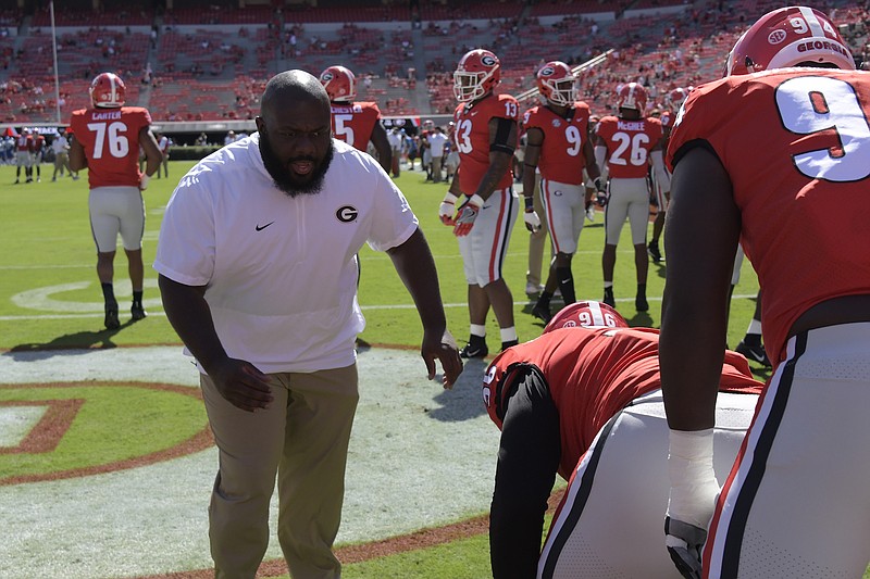 Georgia defensive line coach Tray Scott works with linemen DaQuan Hawkins-Muckle and Michael Barnett before a September game against Middle Tennessee State at Sanford Stadium.