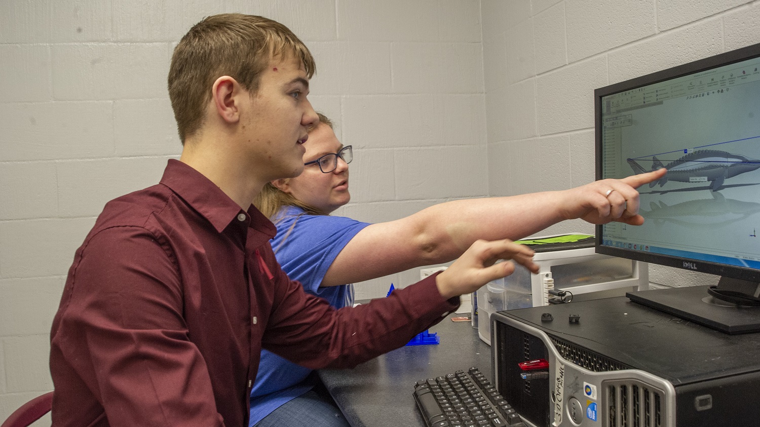 Dade County High School students Logan Gordy (left) and Taryn York look over a 3-D schematic of a LakeSturgeon modeled using computer software. Gordy and York, along with fellow student Dakota Angle, designed, 3-D printed and assembled the six-foot-long model and presented it to the Tennessee Aquarium Conservation Institute on Monday, Dec. 17. Photo credit: Casey Phillips / Tennessee Aquarium. Contributed Photo/Times Free Press