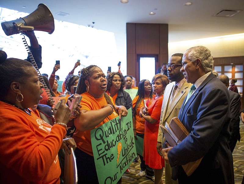 This Oct. 15, 2016 photo shows parents and grandparents from Memphis Lift speaking to Hilary Shelton, the Director to the NAACP's Washington Bureau and Senior Vice President for Advocacy and Policy, during the national NAACP board meeting in downtown Cincinnati. While some black leaders see charters as a safer, better alternative in their communities, a deep rift of opinion was exposed by a 2016 call for a moratorium on charters by the NAACP, a longtime skeptic that expressed concerns about school privatization and accountability issues surrounding charters. (The Cincinnati Enquirer via AP)

