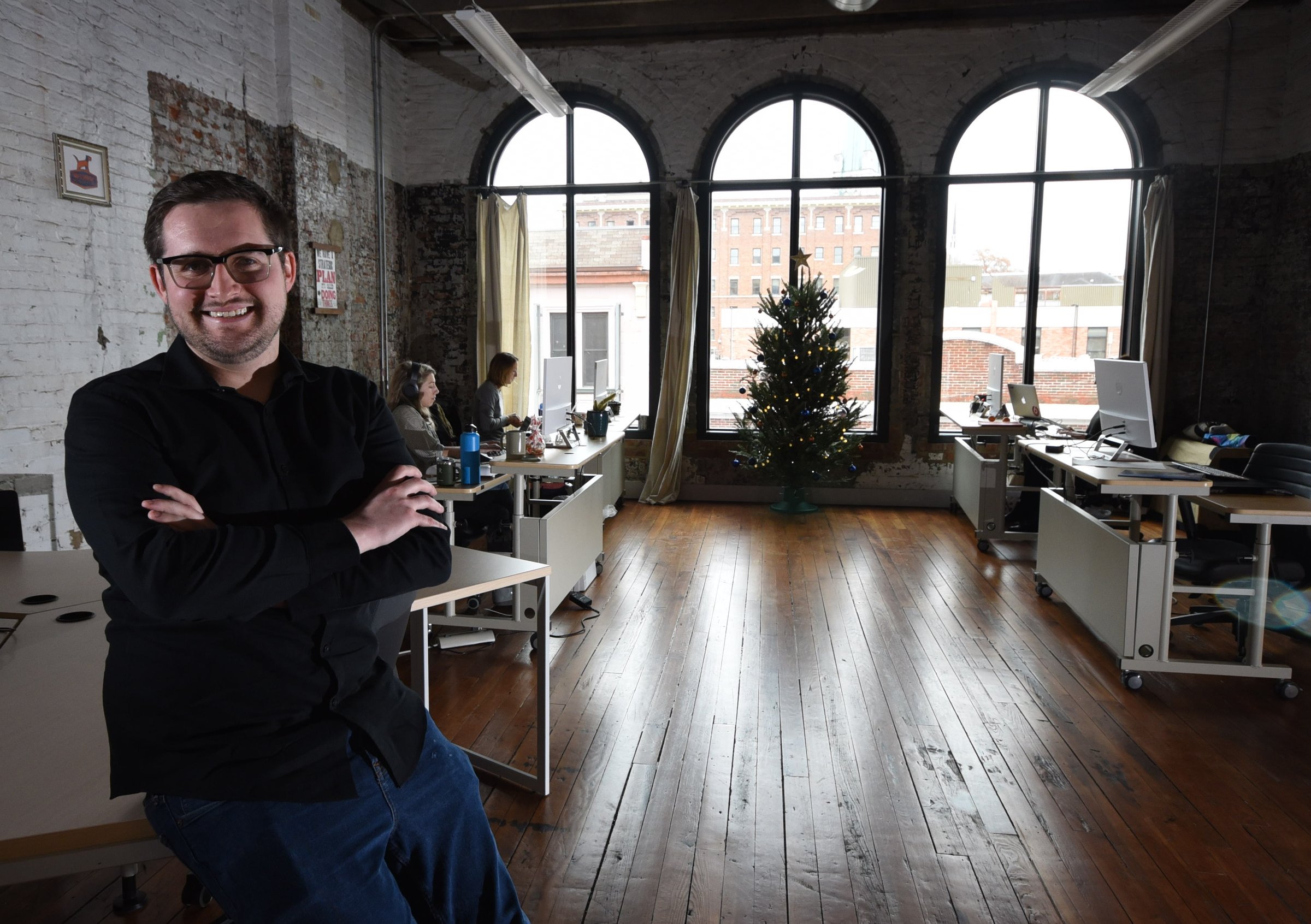 Max Farrell, CEO of Work Hound, sits in the third floor Cherry Street office workspace.
