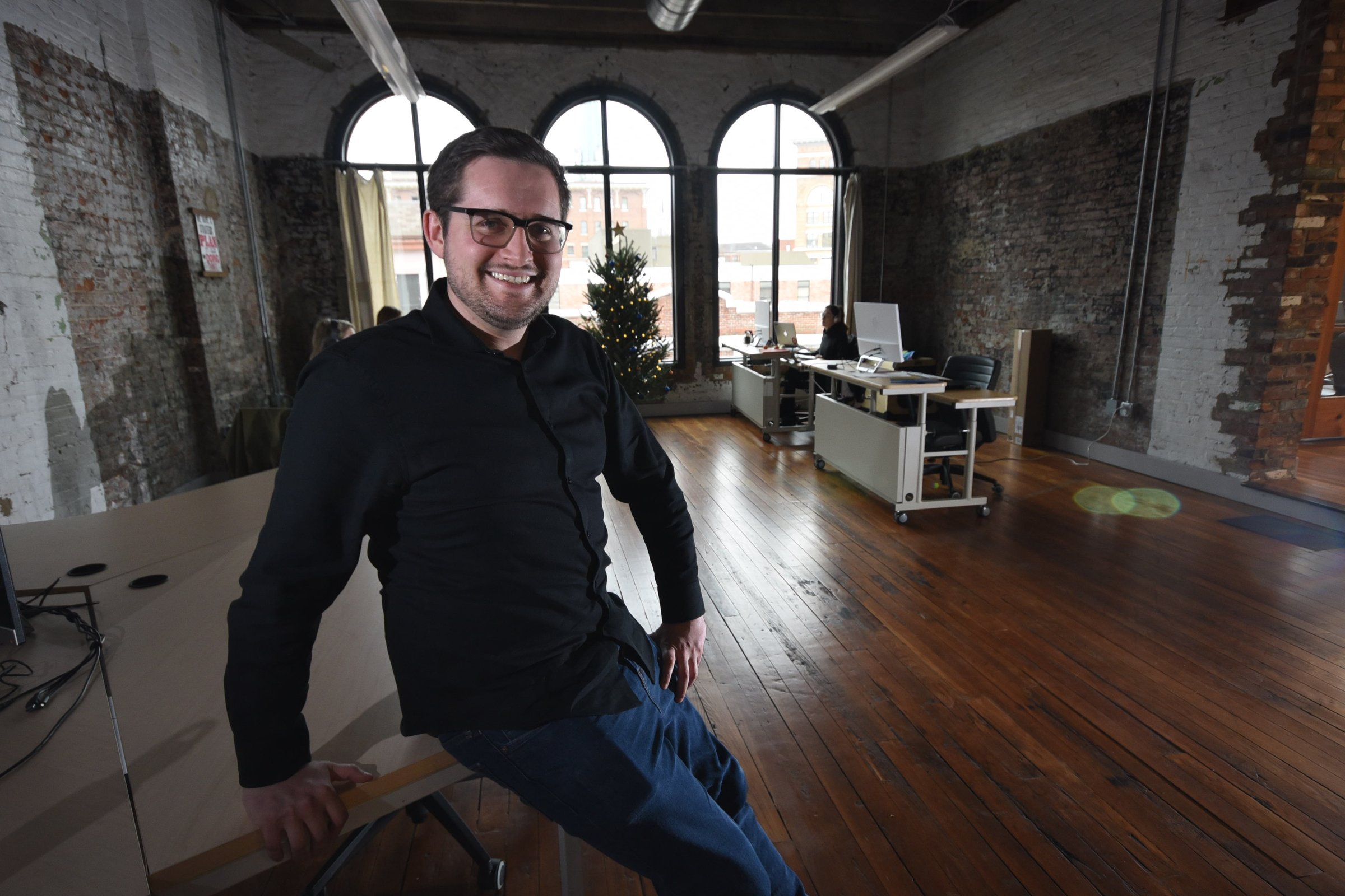 Max Farrell, CEO of Work Hound, sits in the third floor Cherry Street office workspace.