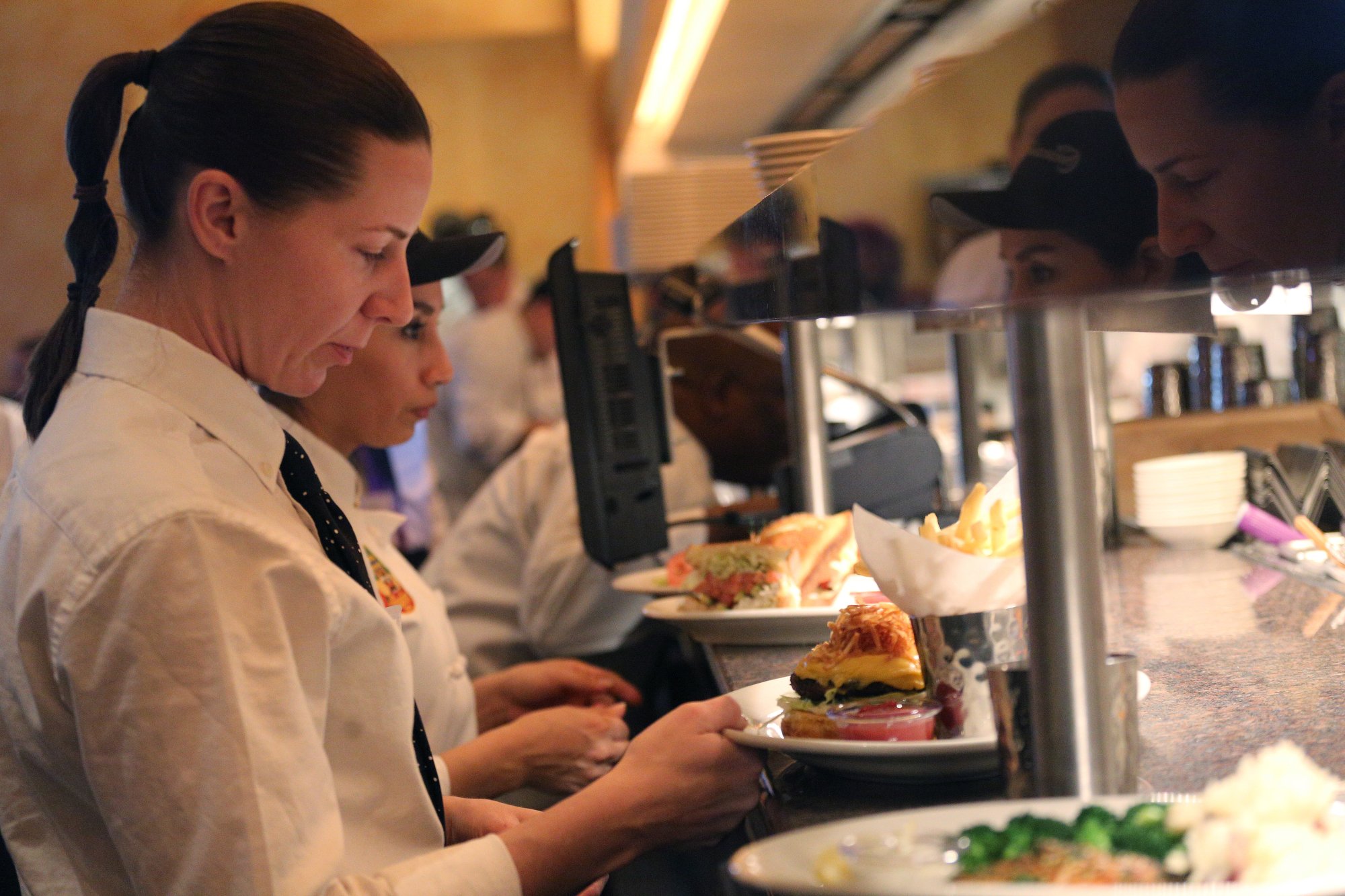 Keshia Songer, a server, grabs food from the line to deliver to a table at the Cheesecake Factory Thursday, November 29, 2018 in Chattanooga, Tennessee. The restaurant will employ 270 individuals.