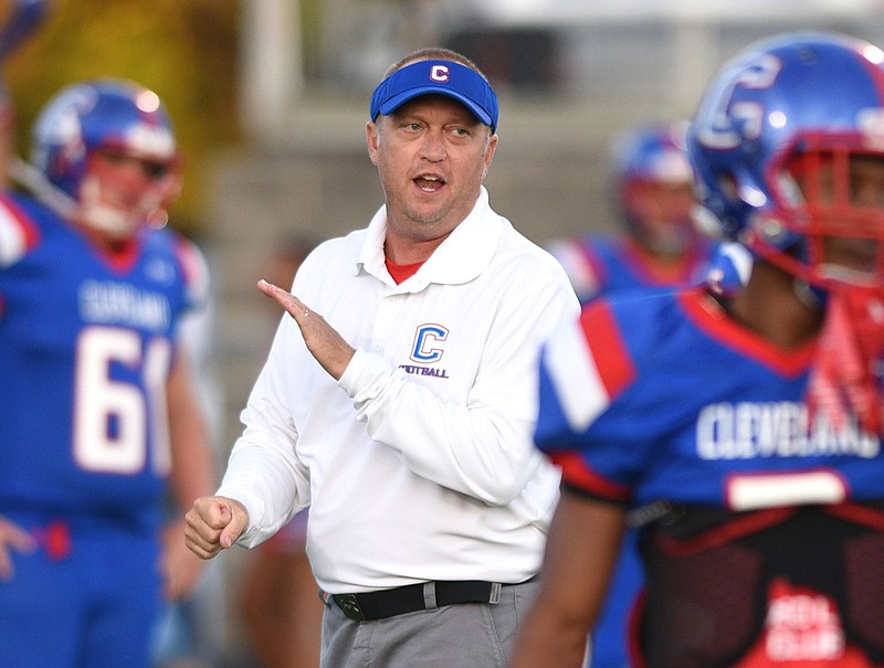 Scott Cummings encourages the Cleveland High School football team as it warms up for a game in 2017. Cummings resigned Thursday after four seasons as the Blue Raiders' head coach to take charge of the program at Halls High School in Knoxville.