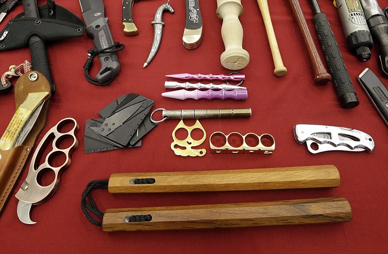 In this April 6, 2017, file photo, objects confiscated from passengers' carry-on luggage, including nunchucks, bottom, are displayed at Seattle-Tacoma International Airport in SeaTac, Wash. A federal court says New York's ban on nunchucks, the martial arts weapon made famous by Bruce Lee but prohibited in the state for decades, is unconstitutional under the Second Amendment. (AP Photo/Elaine Thompson, File)