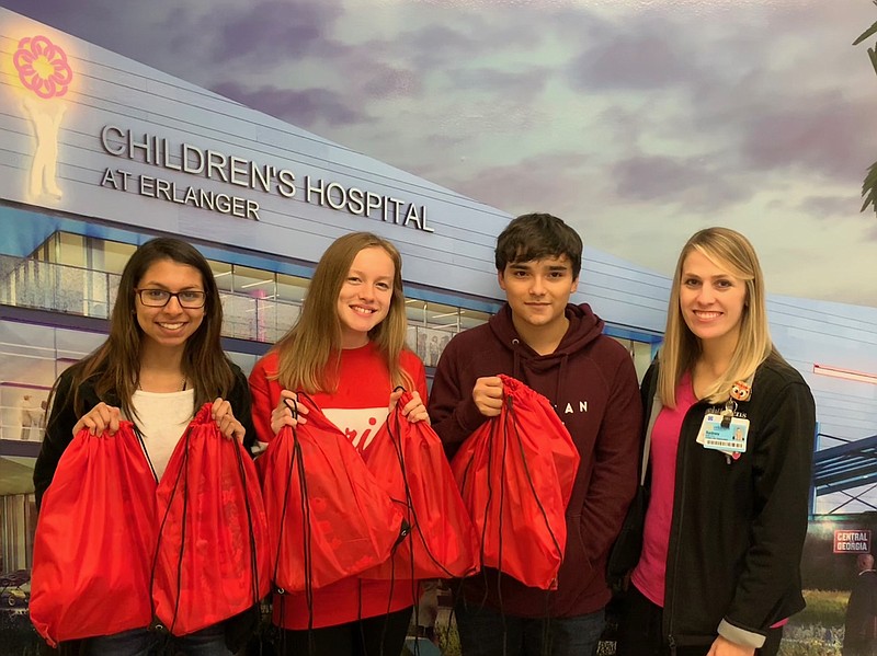 Shaili Patel, Sydnee Brown and Gabe Magnuson, from left, DECA students from Lakeview-Fort Oglethorpe High, deliver "Little Warrior Battle Bags" to Sydney Smith at Children's Hospital at Erlanger just in time for the holidays. (Contributed photo)
