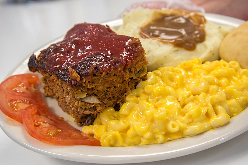 A thick slice of meatloaf served with mashed potatoes and gravy, mac and cheese and sliced tomatoes at Track's End. (Photo by Mark Gilliland)