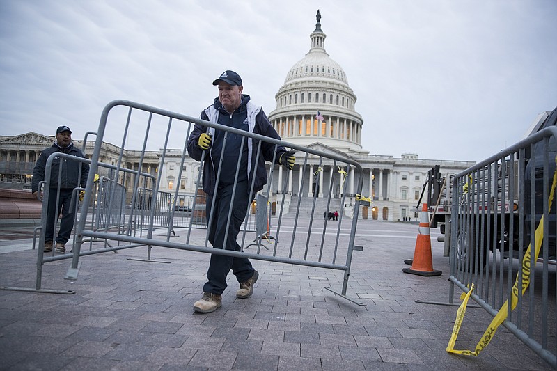 A Capitol worker arranges barricades in Washington Thursday during the partial government shutdown. (Sarah Silbiger/The New York Times)