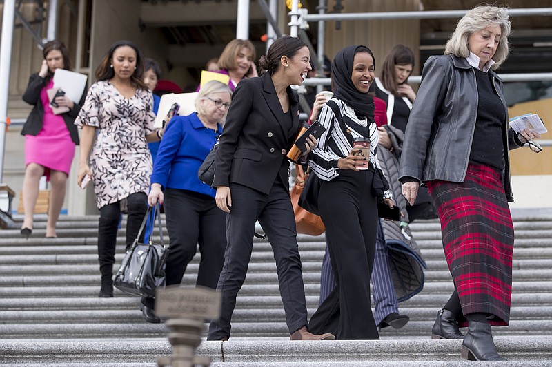 Rep. Alexandria Ocasio-Cortez, D-New York, center left, and Rep. Ilhan Omar, D-Minnesota, center right, share a laugh as they walk down the House steps to take a group photograph of the House Democratic women members of the 116th Congress on the East Front Capitol Plaza on Capitol Hill in Washington on Friday as the 116th Congress begins. Also pictured is Rep. Dina Titus, D-Nevada, right. (AP Photo/Andrew Harnik)