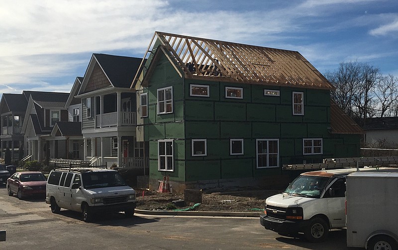 Workers tear down the framing on the latest GreenTech home built on Adams Street because it was inadvertently erected on Norfolk Southern Railway property. GreenTech was unable to negotiate an acceptable price for the parcel after erecting most of the house last year and has to clear the homesite for an alley to provide egress to other homeowners.