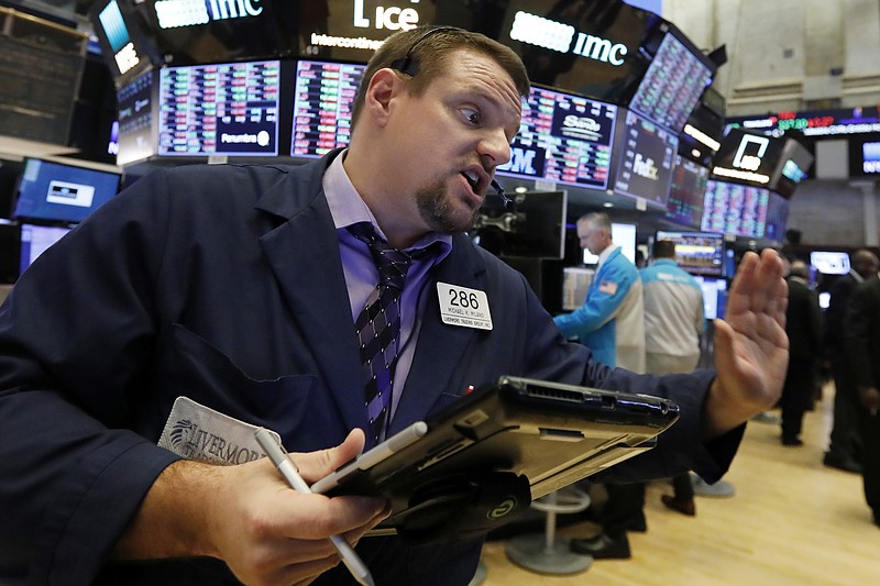 FILE - In a Thursday, Jan. 3, 2019 file photo, trader Michael Milano works on the floor of the New York Stock Exchange. One recent characteristic of the stock market is that every day can feel like bedlam. Investors have been careening from fear to relief and back again depending on the latest news. More tests of the market’s mettle lie ahead, with U.S.-China trade talks, the fourth-quarter earnings period and another Federal Reserve meeting on the horizon.  (AP Photo/Richard Drew, File)