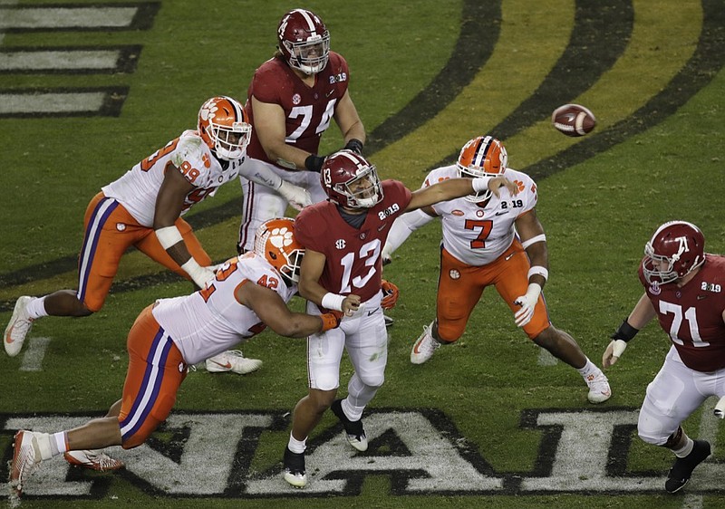 Alabama's Tua Tagovailoan throws under pressure during the second half of the NCAA college football playoff championship game against Clemson, Monday, Jan. 7, 2019, in Santa Clara, Calif. (AP Photo/Jeff Chiu)

