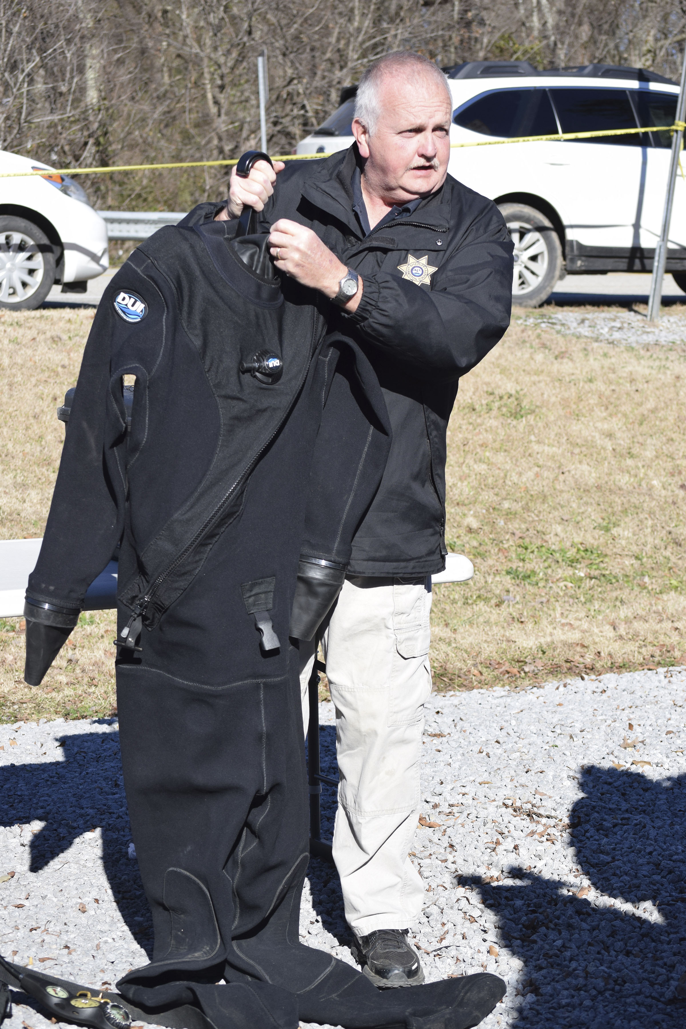 John Scruggs, one of 10 divers on the Hamilton County Sheriff's Office forensic dive team, describes how dry suits work that are being used by divers in the search for a missing pilot and his plane on Chickamauga Lake. / Staff Photo by Ben Benton