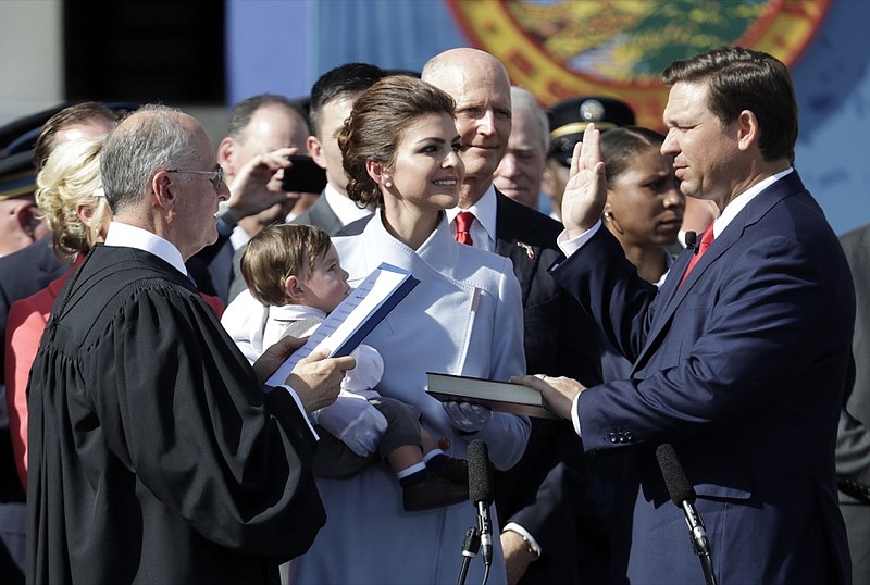 Ron DeSantis, right, is sworn in as Florida Governor by Chief Justice Charles Canady, left, as his wife Casey and son Mason look on, Tuesday, Jan. 8, 2019, in Tallahassee, Fla. Republicans will begin their third decade dominating the state's Capitol. At center is former Gov. Rick Scott. (AP Photo/Lynne Sladky)

