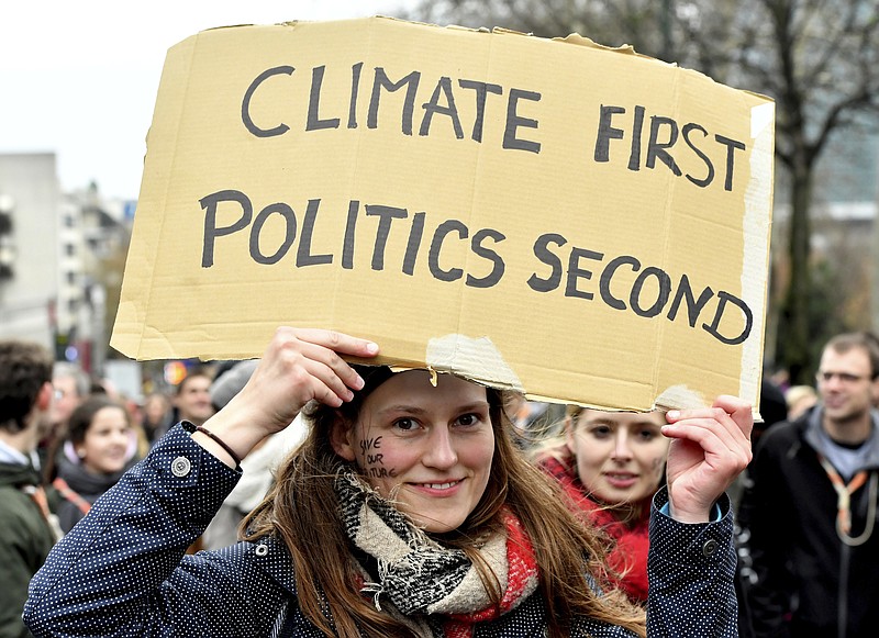 A demonstrator holds a placard which reads 'climate first, politics second' during a 'Claim the Climate' march in Brussels, last month. (AP Photo/Geert Vanden Wijngaert)