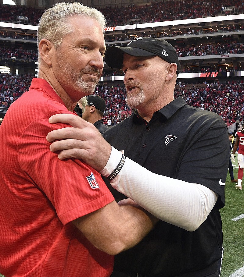 Atlanta Falcons coach Dan Quinn, right, speaks with Dirk Koetter — the Tampa Bay Buccaneers' coach at the time — after their teams' game on Oct. 14 in Atlanta. The Bucs fired Koetter after the regular-season finale, and Quinn hired Koetter as Atlanta's offensive coordinator this week.