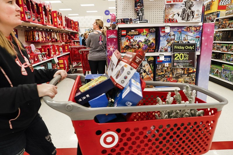 FILE- In this Nov. 23, 2018, file photo shoppers browse the aisles during a Black Friday sale at a Target store in Newport, Ky. Target on Thursday, Jan. 10, 2019, posted strong online growth in November and December. Sales for merchandise ordered online and picked up at stores surged 60 percent. (AP Photo/John Minchillo, File)

