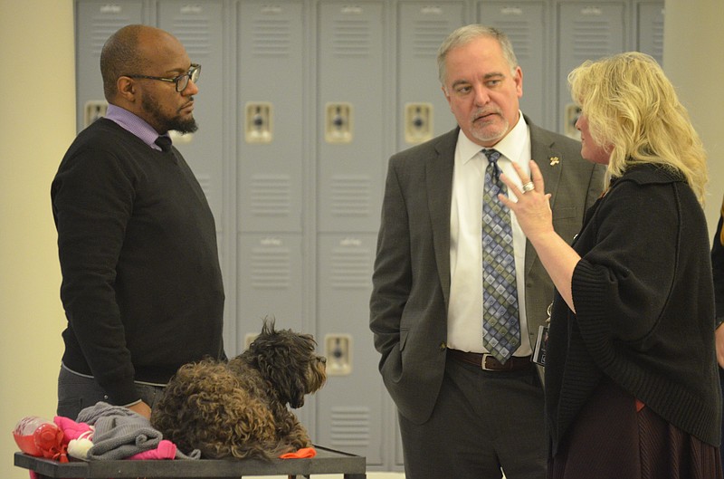 Beverly Hedges, right, tells Georgia State School Superintendent Richard Woods and fellow education officials on the Jan. 9 tour about the benefits that Jag, a registered therapy dog, has had for students at LaFayette High School, as the pooch looks on. (Staff photo by Myron Madden)