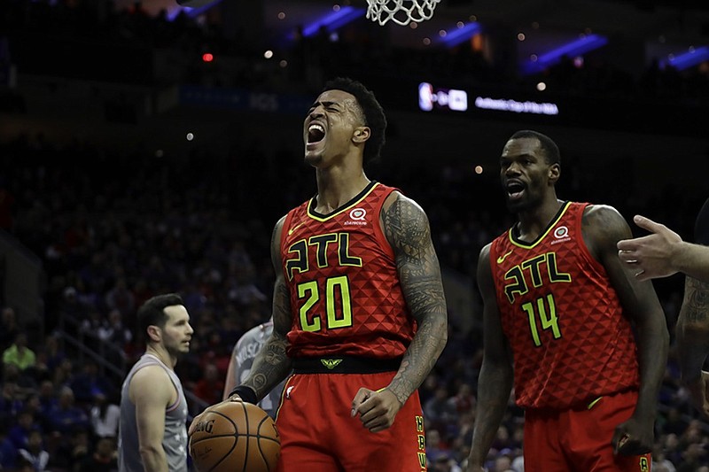 The Atlanta Hawks' John Collins, left, and Dewayne Dedmon celebrate during Friday night's 123-121 upset of the 76ers in Philadelphia. Collins hit a fadeaway jumper to put the Hawks ahead in the final 30 seconds, and they held on as the Sixers stumbled.