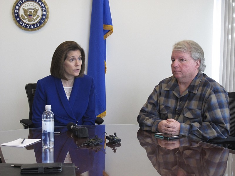 David Pritchett, a furloughed worker for the U.S. Bureau of Land Management, looks on as Sen. Catherine Cortez Masto, D-Nev., talks to reporters Friday, Jan. 11, 2019, in her office in Reno about the impacts of the partial government shutdown. Pritchett, a BLM planner in Reno, says the effects of the shutdown will have a ripple effect on federal land management long after the government fully reopens because of deadlines that were missed for federal permits on a whole range of projects, from gold mines to large recreational events. (AP Photo/Scott Sonner)

