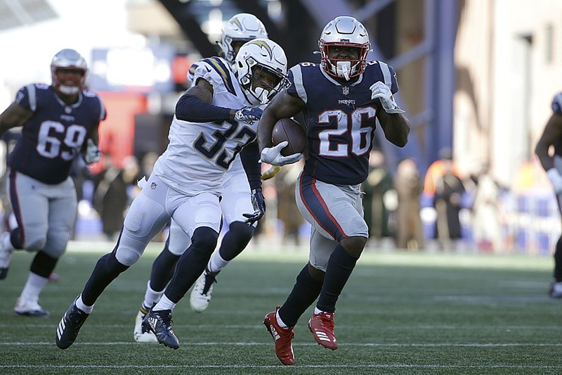 New England Patriots running back Sony Michel (26) slips away from Los Angeles Chargers free safety Derwin James (33) during the first half of Sunday's AFC divisional-round playoff game in Foxborough, Mass. Michel scored three touchdowns to help the Patriots win 41-28.
