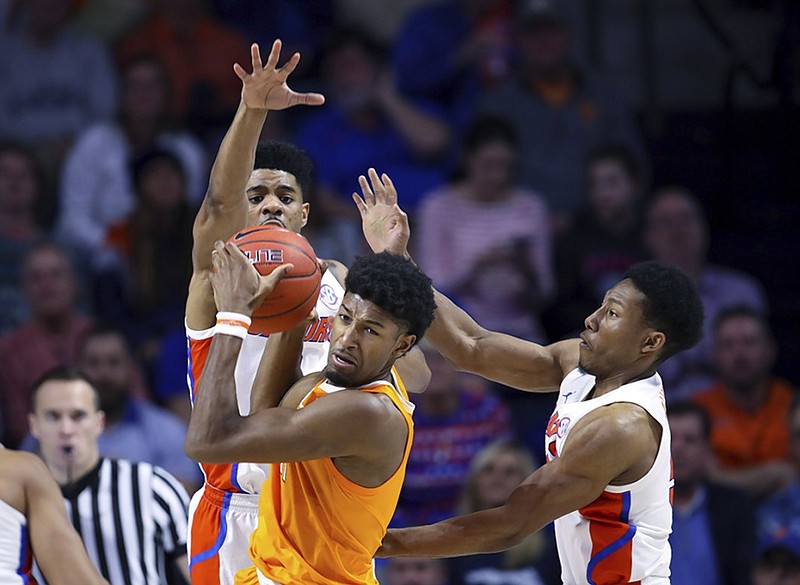 Tennessee forward Kyle Alexander grabs an offensive rebound in front of Florida's Jalen Hudson, left, and KeVaughn Allen during the second half of Saturday's game in Gainesville, Fla.