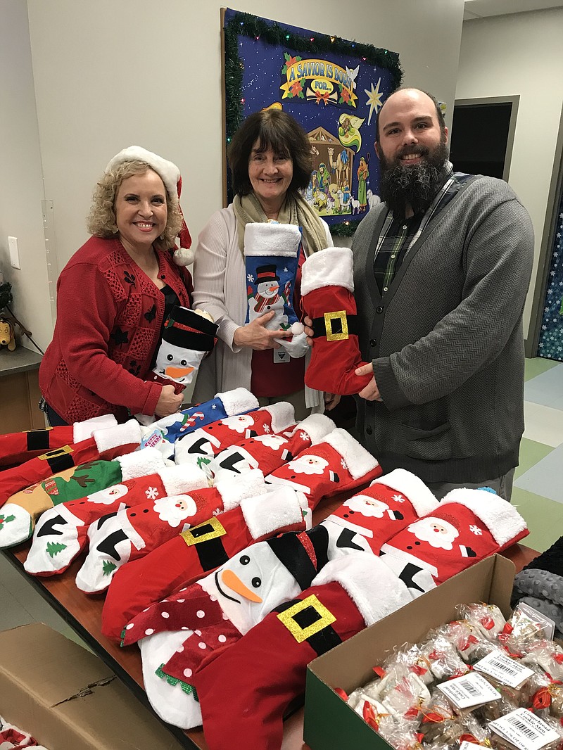 Representatives from the Maclellan Shelter for Families accept gifts delivered by Marcella Hullander, at left, that were donated by members of Cornerstone Community Church.
